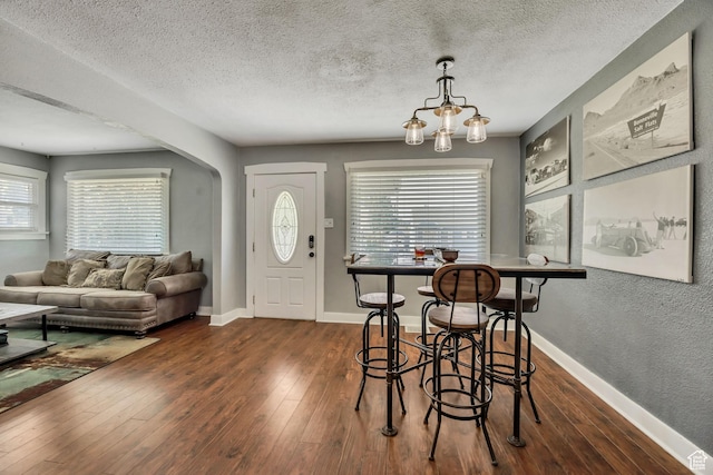 763 E Spring View Dr, Millcreek, UT 84106 - dining area with a textured ceiling, dark wood-type flooring, and arched walkways