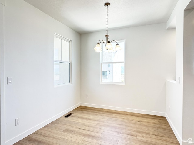 6648 W 11800 S, South Jordan, UT 84009 - unfurnished room with healthy amount of natural light, a chandelier, light wood-style floors, and baseboards