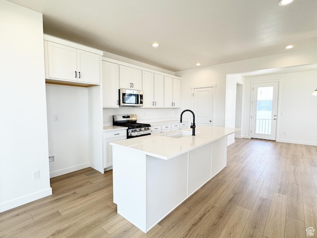 6648 W 11800 S, South Jordan, UT 84009 - kitchen featuring appliances with stainless steel finishes, a sink, light wood-type flooring, white cabinetry, and baseboards