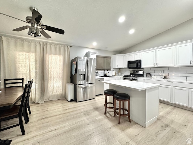 574 N Jackson Ave, Ogden, UT 84404 - kitchen with stainless steel appliances, a center island, light countertops, light wood-style floors, and tasteful backsplash