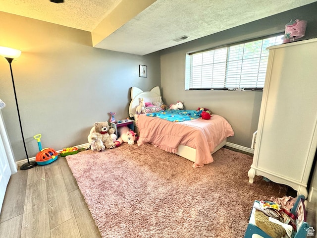 574 N Jackson Ave, Ogden, UT 84404 - bedroom with a textured ceiling, baseboards, and wood finished floors