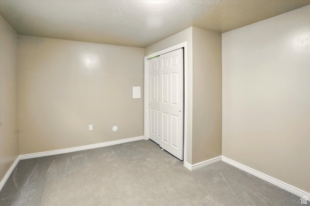 11569 S Oakmond Rd, South Jordan, UT 84009 - unfurnished bedroom with carpet flooring, baseboards, a closet, and a textured ceiling