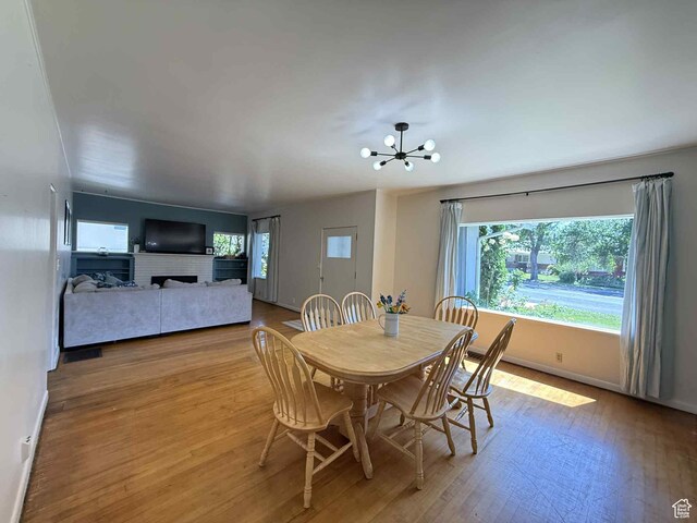 229 N Carbon Ave, Price, UT 84501 - dining room with wood finished floors, a chandelier, baseboards, and a brick fireplace
