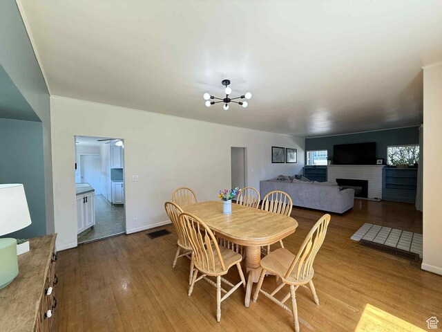 229 N Carbon Ave, Price, UT 84501 - dining room with a chandelier, wood finished floors, a fireplace, and baseboards