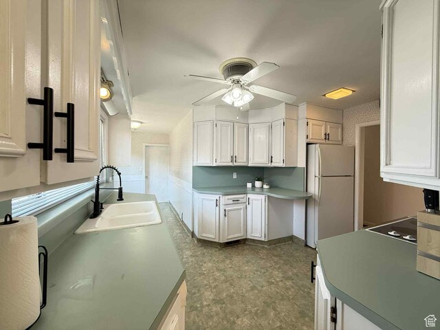 229 N Carbon Ave, Price, UT 84501 - kitchen featuring freestanding refrigerator, a sink, a ceiling fan, white cabinets, and dark flooring