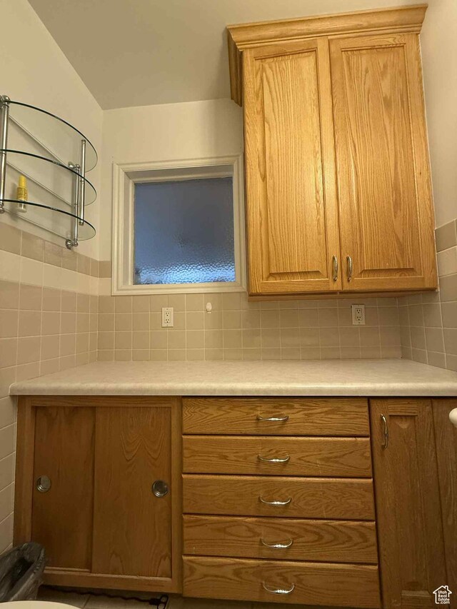 229 N Carbon Ave, Price, UT 84501 - kitchen with light countertops, brown cabinetry, tile walls, and tasteful backsplash