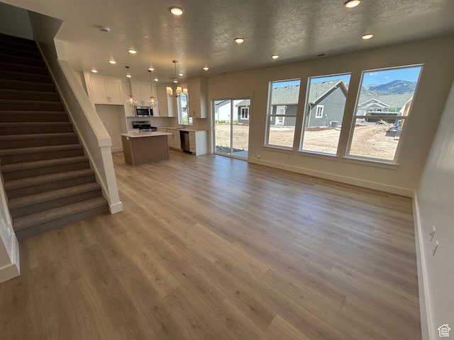 554 N 800 W, Smithfield, UT 84335 - unfurnished living room with baseboards, recessed lighting, light wood-style flooring, and stairs