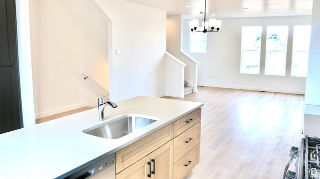 1650 N Main St N Unit 129, Layton, UT 84041 - kitchen featuring a sink, light countertops, light wood-type flooring, pendant lighting, and a chandelier