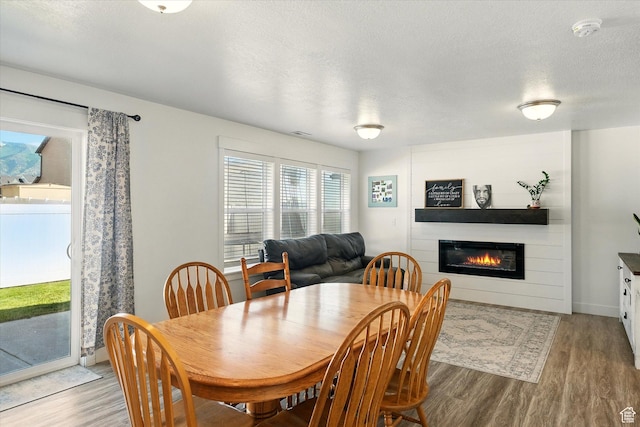 2124 S 1490 W, Wellsville, UT 84339 - dining area with wood finished floors, a large fireplace, and a textured ceiling