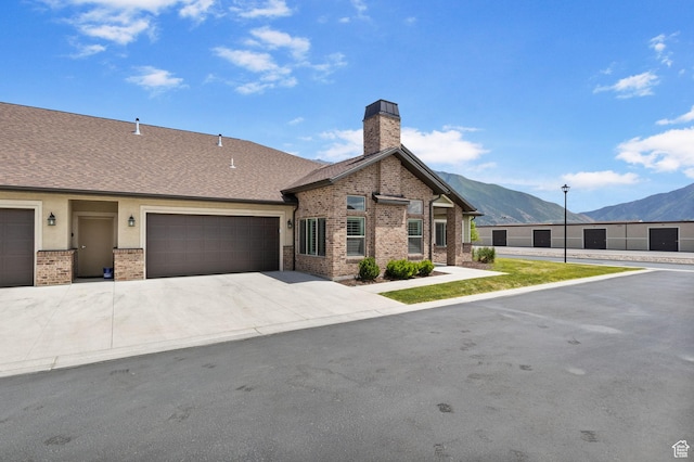 1736 W 300 S Unit D, Mapleton, UT 84664 - view of front facade featuring a mountain view, brick siding, a chimney, concrete driveway, and a garage