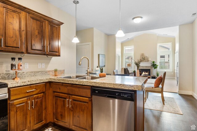 1736 W 300 S Unit D, Mapleton, UT 84664 - kitchen with stainless steel dishwasher, a sink, a peninsula, a warm lit fireplace, and dark wood-style flooring