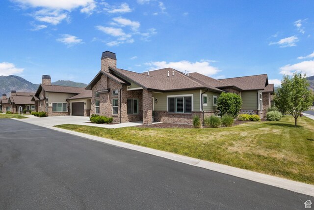1736 W 300 S Unit D, Mapleton, UT 84664 - view of front of home with a garage, a chimney, brick siding, driveway, and a front lawn