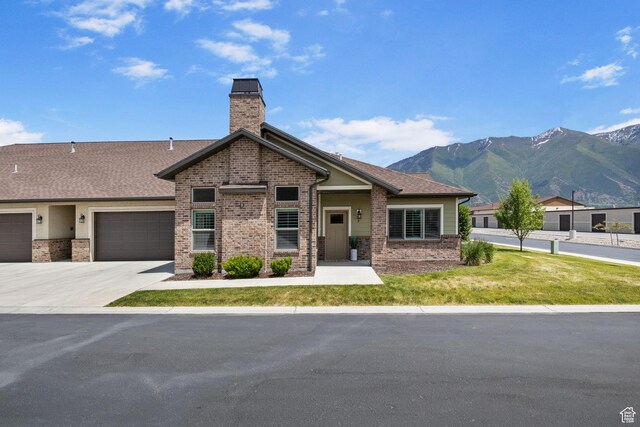 1736 W 300 S Unit D, Mapleton, UT 84664 - view of front facade featuring brick siding, a mountain view, a chimney, a front lawn, and concrete driveway