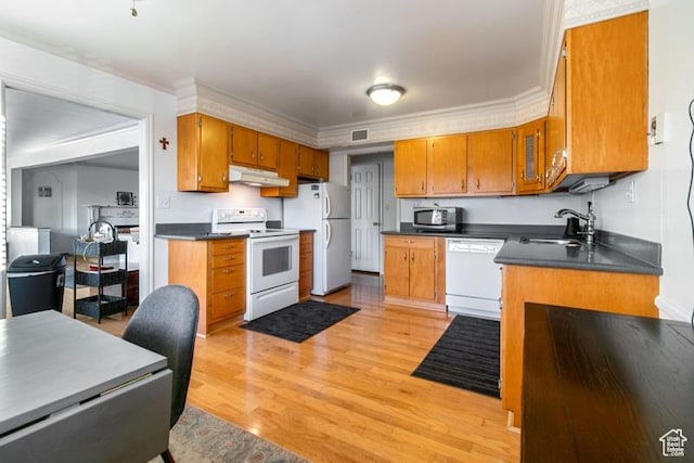 1132 E 2700 S Unit E36, Millcreek, UT 84106 - kitchen featuring white appliances, under cabinet range hood, brown cabinetry, dark countertops, and light wood-type flooring