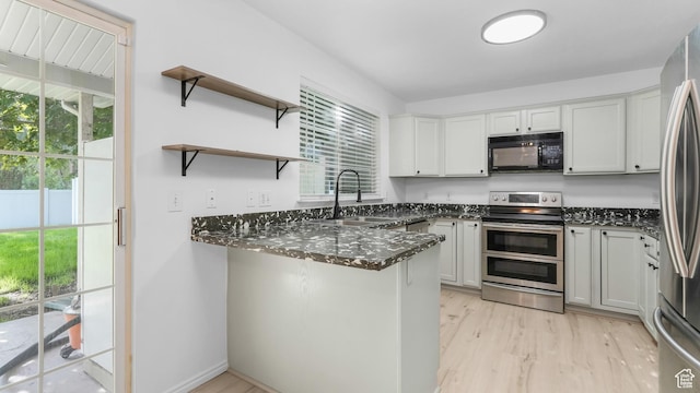 1833 W 7600 S Unit 419, West Jordan, UT 84084 - kitchen featuring stainless steel appliances, a sink, dark stone countertops, and healthy amount of natural light