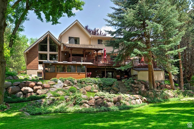 12144 S Mountain Shadow Rd, Sandy, UT 84092 - rear view of property featuring a wooden deck, a lawn, a sunroom, and stucco siding