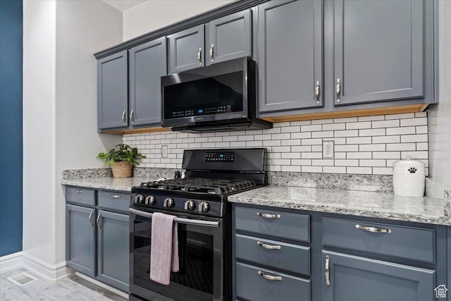 160 S 2875 W, West Point, UT 84015 - kitchen featuring black gas stove, stainless steel microwave, backsplash, light stone countertops, and baseboards