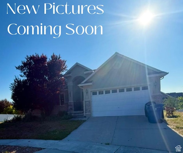 5653 N Poppy Cir, Stansbury Park, UT 84074 - ranch-style house with an attached garage, driveway, and stone siding