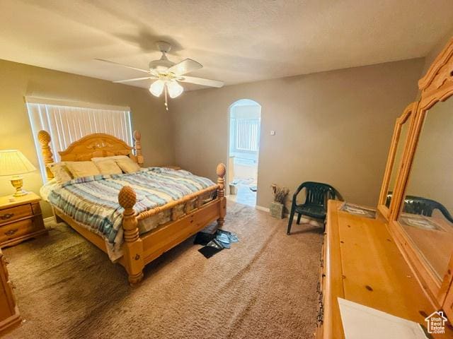 5653 N Poppy Cir, Stansbury Park, UT 84074 - bedroom featuring carpet floors, arched walkways, a ceiling fan, and baseboards