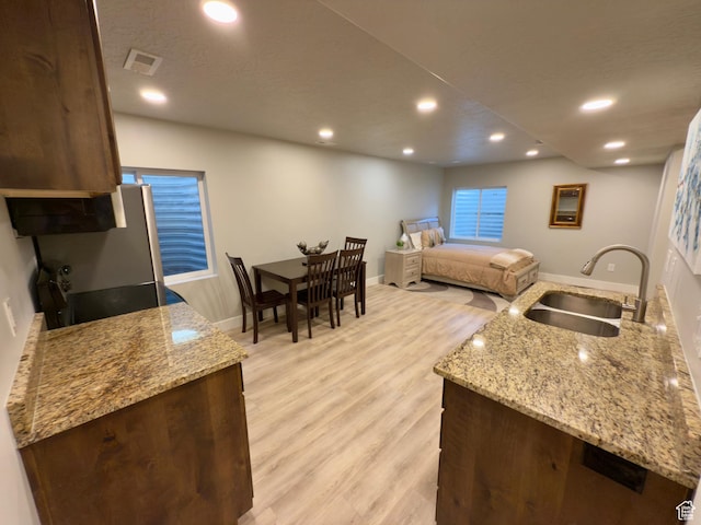 62 S 610 E, American Fork, UT 84003 - kitchen featuring light wood-style floors, recessed lighting, light stone countertops, dark brown cabinetry, and range