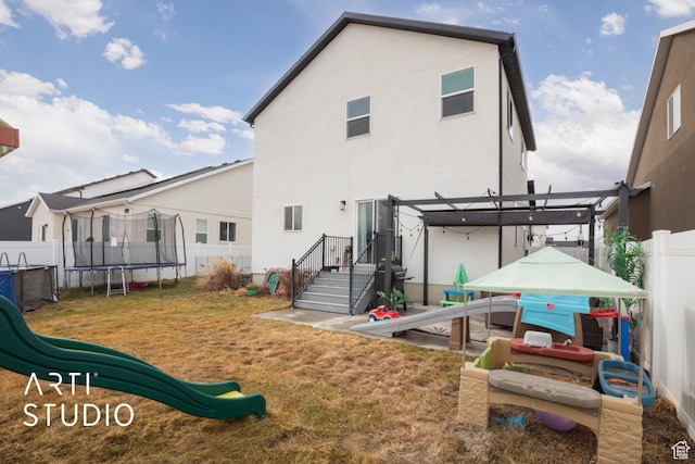 3516 N Willy Way, Eagle Mountain, UT 84005 - rear view of property featuring a trampoline, stucco siding, a pergola, and a playground