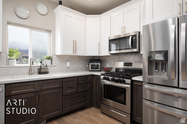 3516 N Willy Way, Eagle Mountain, UT 84005 - kitchen with stainless steel appliances, a sink, light countertops, white cabinets, and tasteful backsplash