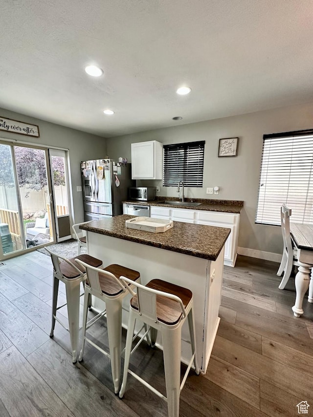 1879 E 1130 S, Spanish Fork, UT 84660 - kitchen with stainless steel appliances, dark wood finished floors, a breakfast bar, white cabinetry, and recessed lighting
