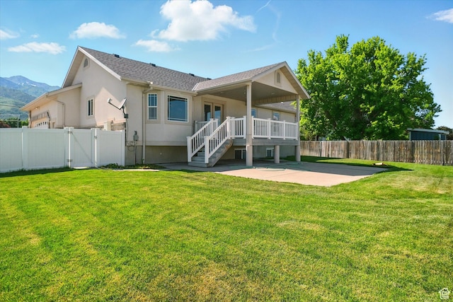 192 S 100 E, Wellsville, UT 84339 - rear view of house with a patio, a fenced backyard, a gate, stucco siding, and a deck with mountain view