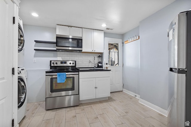 830 W 630 N, Orem, UT 84057 - kitchen featuring appliances with stainless steel finishes, a sink, white cabinets, tasteful backsplash, and dark countertops