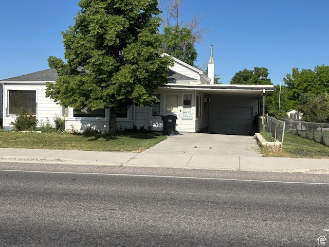 622 S Main St, Gunnison, UT 84634 - obstructed view of property with an attached carport, concrete driveway, a garage, and a chimney