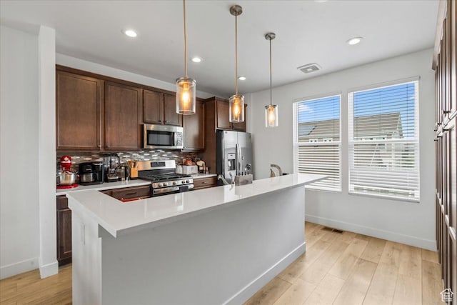 10849 S Lake Run Rd Unit 187, South Jordan, UT 84009 - kitchen featuring stainless steel appliances, tasteful backsplash, light countertops, baseboards, and light wood-type flooring