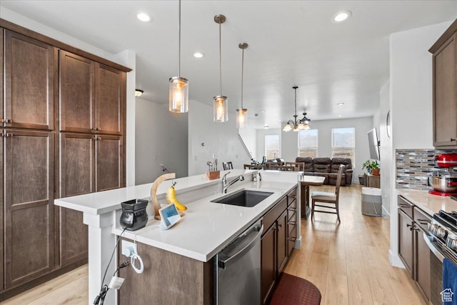 10849 S Lake Run Rd Unit 187, South Jordan, UT 84009 - kitchen with appliances with stainless steel finishes, a sink, light wood-type flooring, open floor plan, and light countertops