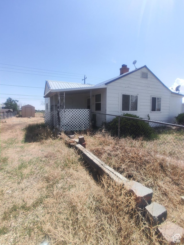 138 W Geneva Dr, East Carbon, UT 84520 - view of front of house featuring a chimney, metal roof, and a standing seam roof