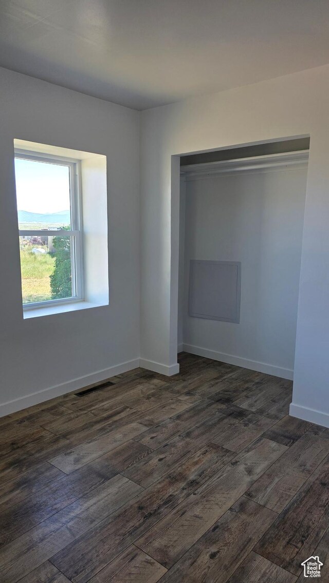 20915 W 1300 S, Malad City, ID 83252 - unfurnished bedroom featuring dark wood finished floors, a closet, and baseboards