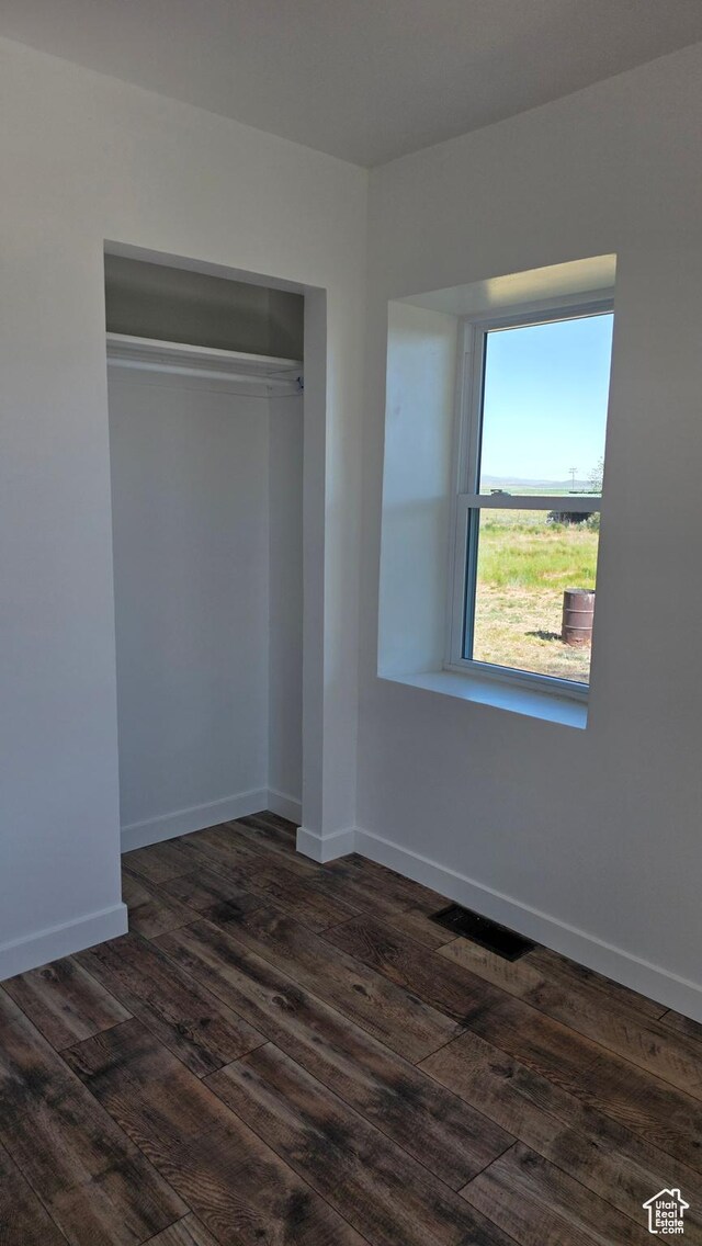 20915 W 1300 S, Malad City, ID 83252 - unfurnished bedroom with dark wood-style floors, baseboards, and a closet