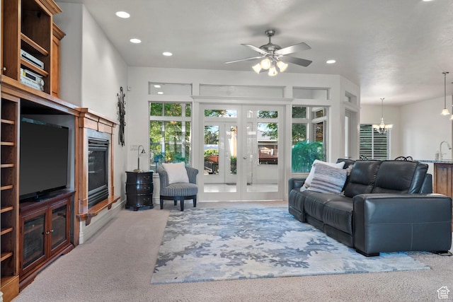 503 W 650 S, Orem, UT 84058 - carpeted living room featuring recessed lighting, a chandelier, french doors, ceiling fan, and a glass covered fireplace