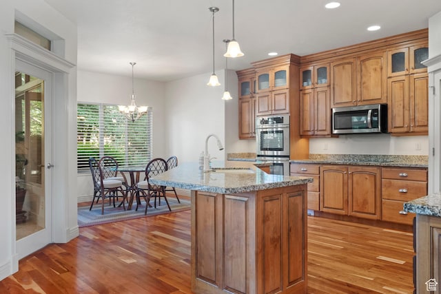 503 W 650 S, Orem, UT 84058 - kitchen featuring stainless steel appliances, a sink, light wood-style flooring, brown cabinets, and pendant lighting