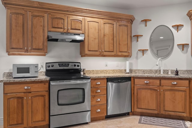 503 W 650 S, Orem, UT 84058 - kitchen with appliances with stainless steel finishes, under cabinet range hood, brown cabinets, light stone countertops, and a sink