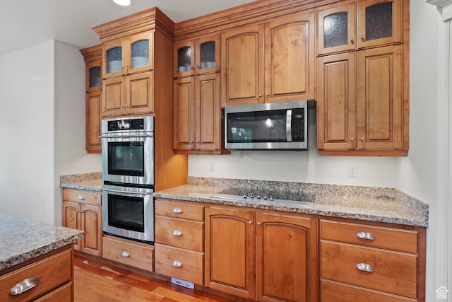 503 W 650 S, Orem, UT 84058 - kitchen with appliances with stainless steel finishes, brown cabinetry, light wood-style floors, and light stone countertops
