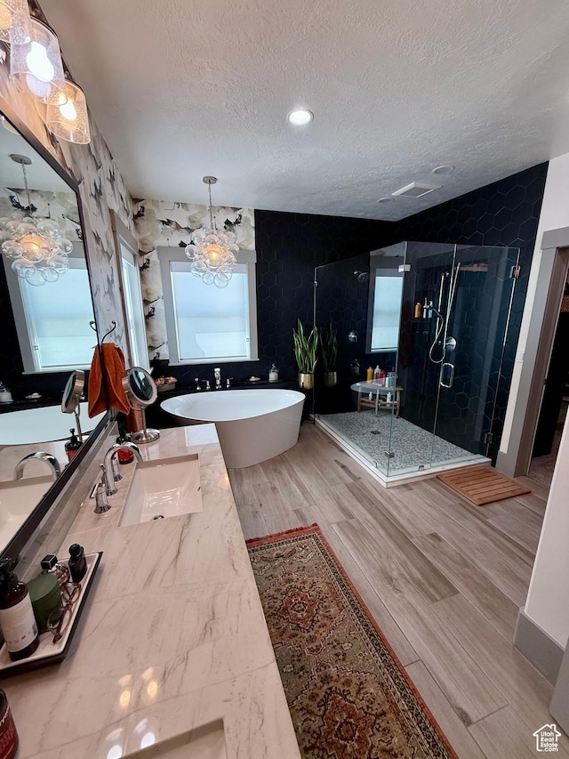 1820 S Kerrybrook Dr, Kaysville, UT 84037 - bathroom featuring a textured ceiling, a soaking tub, a shower stall, double vanity, and wood finished floors
