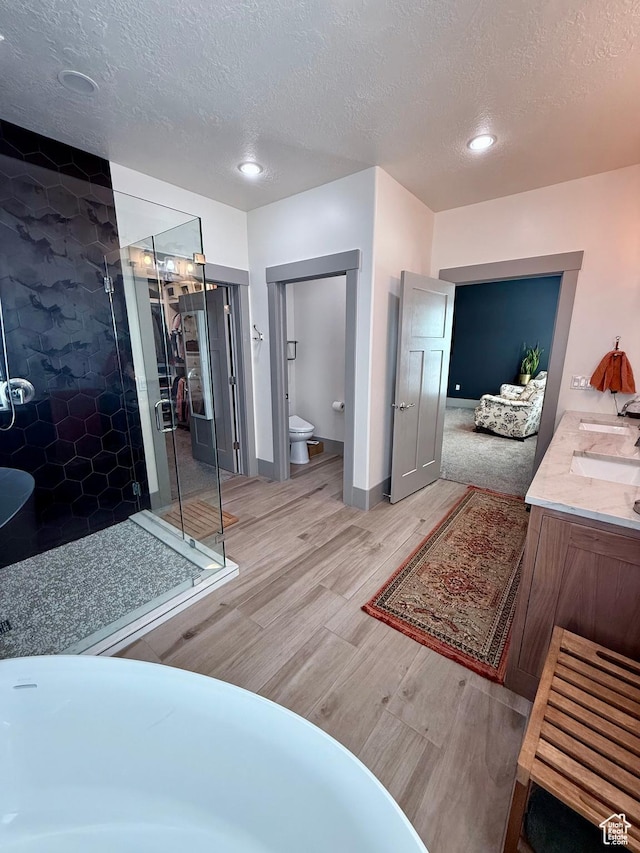 1820 S Kerrybrook Dr, Kaysville, UT 84037 - full bathroom with wood finished floors, a stall shower, a textured ceiling, toilet, and double vanity