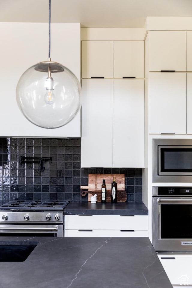10727 N Dosh Ln, Highland, UT 84003 - kitchen with stainless steel appliances, dark countertops, modern cabinets, tasteful backsplash, and white cabinetry