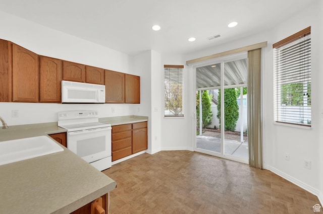 282 Caleb Dr, North Salt Lake, UT 84054 - kitchen with white appliances, a sink, baseboards, light countertops, and recessed lighting