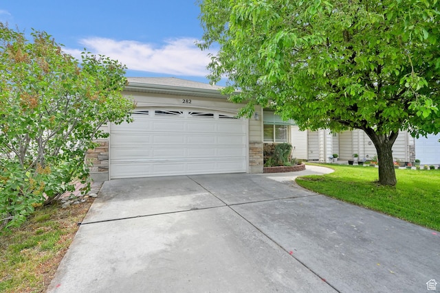 282 Caleb Dr, North Salt Lake, UT 84054 - obstructed view of property featuring concrete driveway, an attached garage, stone siding, and a front yard