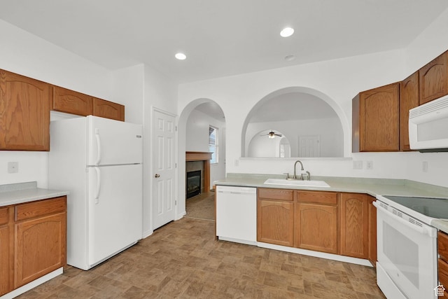282 Caleb Dr, North Salt Lake, UT 84054 - kitchen featuring white appliances, a sink, a glass covered fireplace, a ceiling fan, and light countertops