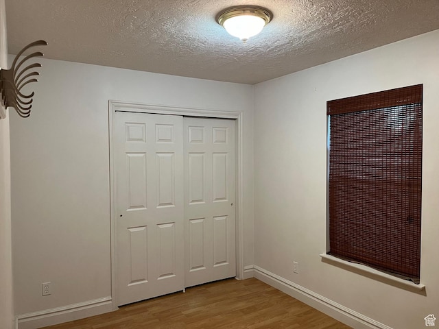 632 W 200 N, Salt Lake City, UT 84116 - unfurnished bedroom with wood finished floors, a textured ceiling, and a closet