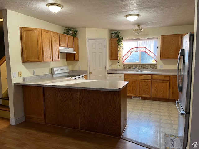 632 W 200 N, Salt Lake City, UT 84116 - kitchen with white appliances, a peninsula, under cabinet range hood, a textured ceiling, and brown cabinetry