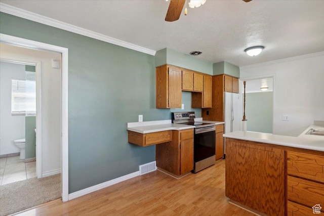 920 N 200 W, Bountiful, UT 84010 - kitchen with electric range, ceiling fan, brown cabinetry, baseboards, and light wood-type flooring