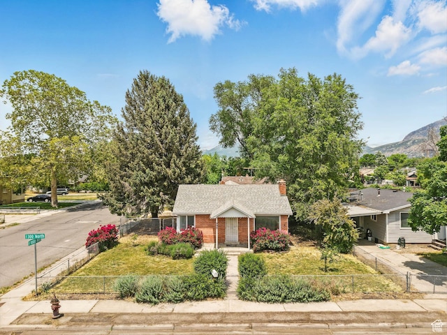 990 W 300 N, Provo, UT 84601 - view of front of house with brick siding, concrete driveway, a chimney, roof with shingles, and a mountain view