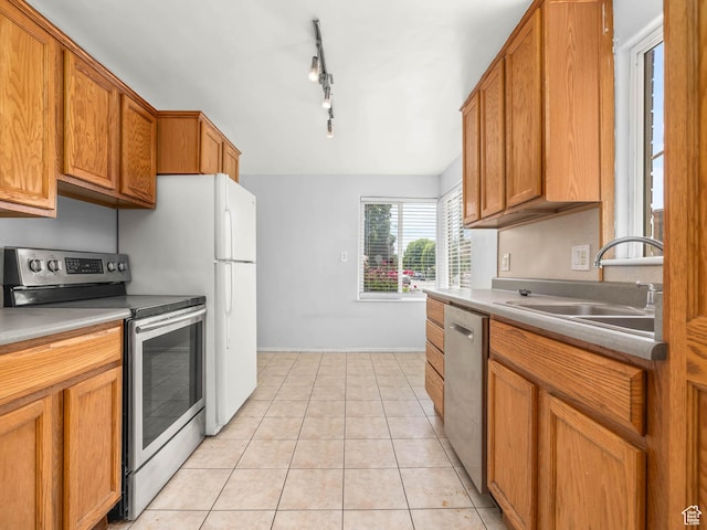 990 W 300 N, Provo, UT 84601 - kitchen featuring appliances with stainless steel finishes, a sink, brown cabinetry, and light tile patterned flooring